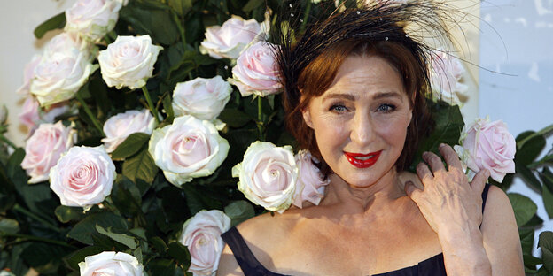 Eine Frau steht vor Rosen Eine Frau steht vor Rosen