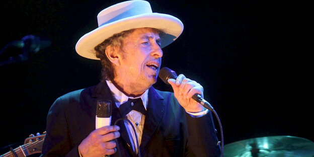 Bob Dylan mit Hut auf dem Kopf und Mikro in der Hand Bob Dylan mit Hut auf dem Kopf und Mikro in der Hand