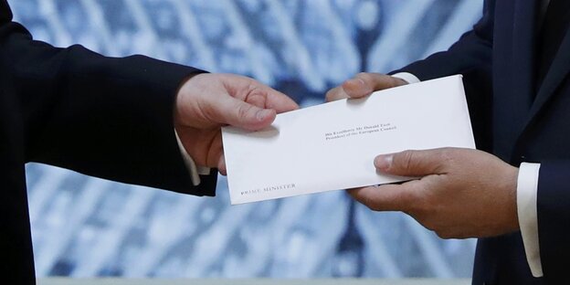 Zwei Personen halten einen Brief. Man sieht nur ihre Hände undf den Brief Zwei Personen halten einen Brief. Man sieht nur ihre Hände undf den Brief