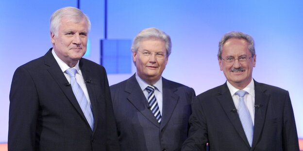 Drei Männer in Anzügen in einem Fernsehstudio Drei Männer in Anzügen in einem Fernsehstudio