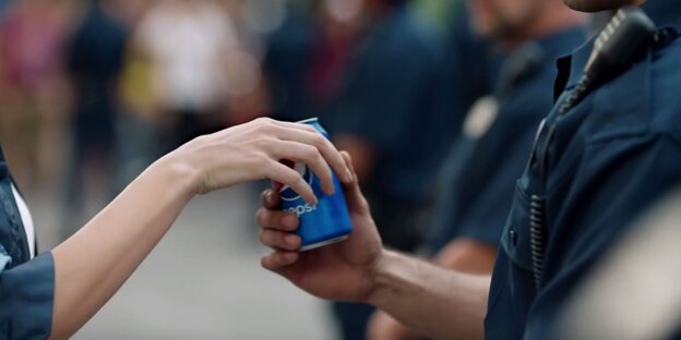 Eine Hand reicht ener andeen eine Dose Pepsi-Cola Eine Hand reicht ener andeen eine Dose Pepsi-Cola