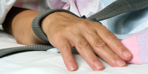 Hand mit Fesselungsgurt. Hand mit Fesselungsgurt.