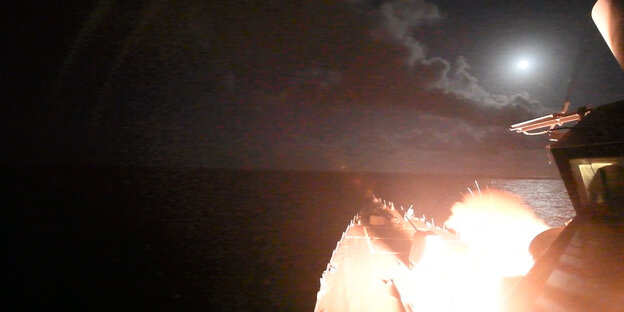 Im Dunkeln startet eine Rakete mit einer Explosion von einem Schiff Im Dunkeln startet eine Rakete mit einer Explosion von einem Schiff
