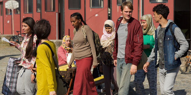 Eine Gruppe Menschen geht zusammen nach links im Bild Eine Gruppe Menschen geht zusammen nach links im Bild