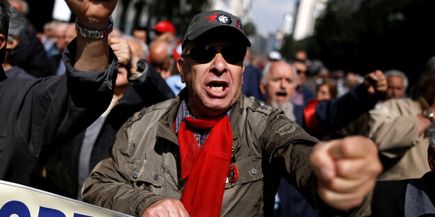 Demonstrant mit Che-Guevara-Mütze ballt die Faust Demonstrant mit Che-Guevara-Mütze ballt die Faust