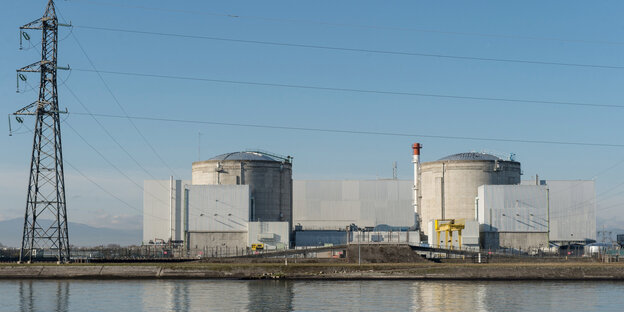 Vor strahlend blauem Himmel steht das Atomkraftwerk Fessenheim und spiegelt sich im Wasser Vor strahlend blauem Himmel steht das Atomkraftwerk Fessenheim und spiegelt sich im Wasser