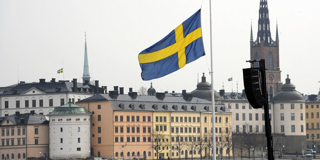 Flagge weht vor Häusern auf Halbmast Flagge weht vor Häusern auf Halbmast