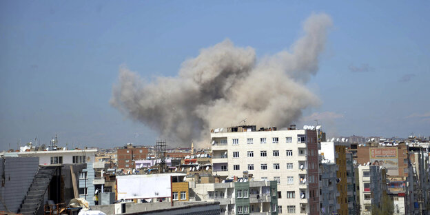 Eine graue Rauchwolke steigt über dem hellblauen Himmel über Diyarbakir auf Eine graue Rauchwolke steigt über dem hellblauen Himmel über Diyarbakir auf