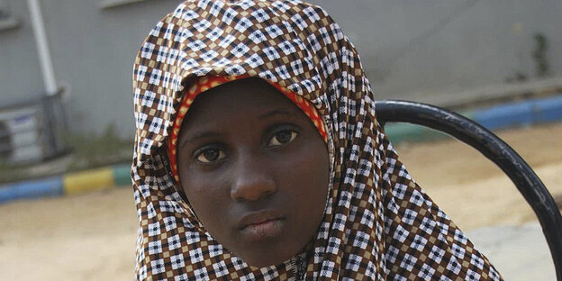 Ein Mädchen mit rot-weißem Kopftuch aus Nigeria Ein Mädchen mit rot-weißem Kopftuch aus Nigeria