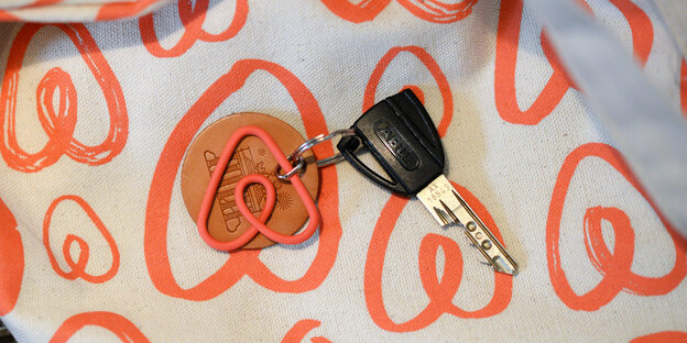 Ein Schlüssel mit einem Anhänger in Form des Airbnb-Logos Ein Schlüssel mit einem Anhänger in Form des Airbnb-Logos