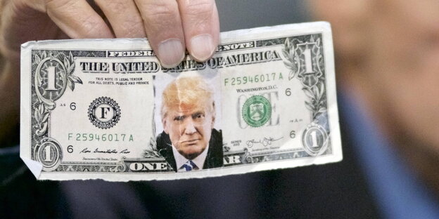 Trump-Unterstützer Jerry Lambert hält einen Dollarschein mit einem Bild von Donald Trump in die Kamera Trump-Unterstützer Jerry Lambert hält einen Dollarschein mit einem Bild von Donald Trump in die Kamera