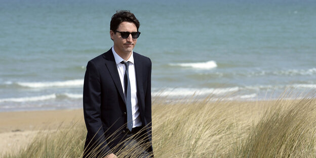 Justin Trudeau in schwarzem Anzug mit Sonnenbrille am Strand Justin Trudeau in schwarzem Anzug mit Sonnenbrille am Strand