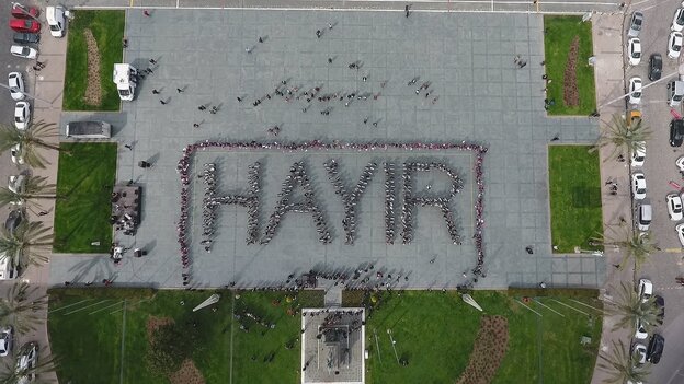Aufsicht auf einen Platz, auf dem eine Gruppe von Menschen sich so zueinander gestellt hat, dass sie das Wort "Hayir" bildet. Aufsicht auf einen Platz, auf dem eine Gruppe von Menschen sich so zueinander gestellt hat, dass sie das Wort "Hayir" bildet.