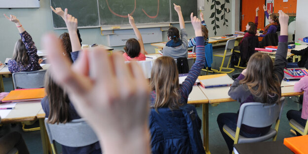 Schülerinnen und Schüler melden sich in einem Klassenraum Schülerinnen und Schüler melden sich in einem Klassenraum