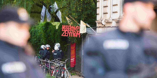 Behelmte Polizisten stehen vor dem Kollektiven Zentrum Behelmte Polizisten stehen vor dem Kollektiven Zentrum