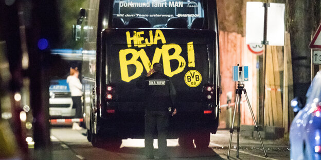 Polizisten stehen in der Nacht vor dem attackierten BVB-Bus, auf dem gelb auf schwarz Heja BVB steht Polizisten stehen in der Nacht vor dem attackierten BVB-Bus, auf dem gelb auf schwarz Heja BVB steht