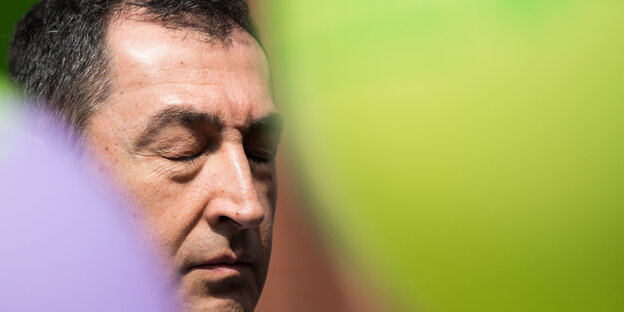 Cem Özdemir mit geschlossenen Augen zwischen zwei Ballons Cem Özdemir mit geschlossenen Augen zwischen zwei Ballons
