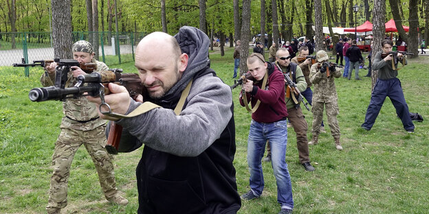 Männer mit Gewehren bei einem Waffentraining Männer mit Gewehren bei einem Waffentraining