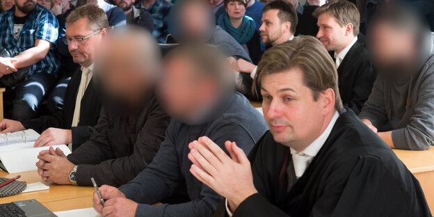 Menschen sitzen in einem Gerichtssaal Menschen sitzen in einem Gerichtssaal