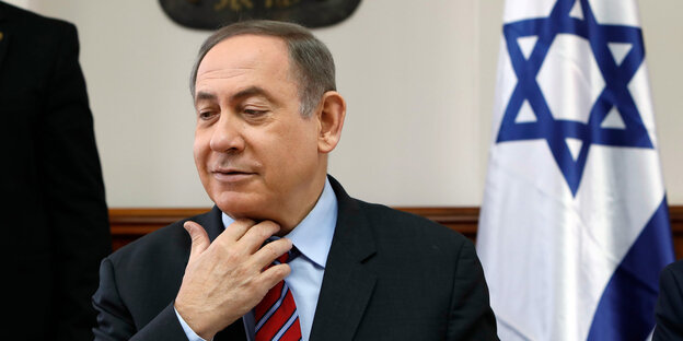 Israels Ministerpräsident Netanjahu lächelt süffisant und lockert sich die Krawatte Israels Ministerpräsident Netanjahu lächelt süffisant und lockert sich die Krawatte