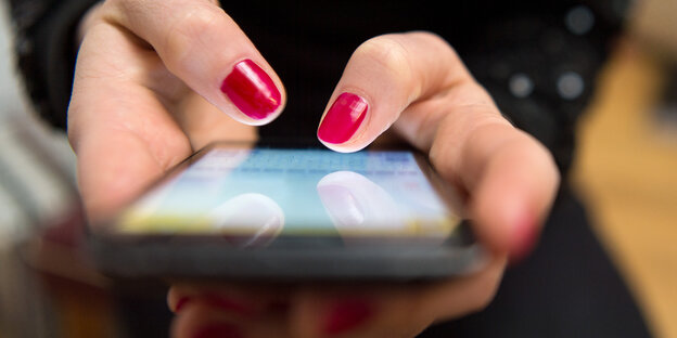Eine Fraui tippt auf einem Smartphone Eine Fraui tippt auf einem Smartphone