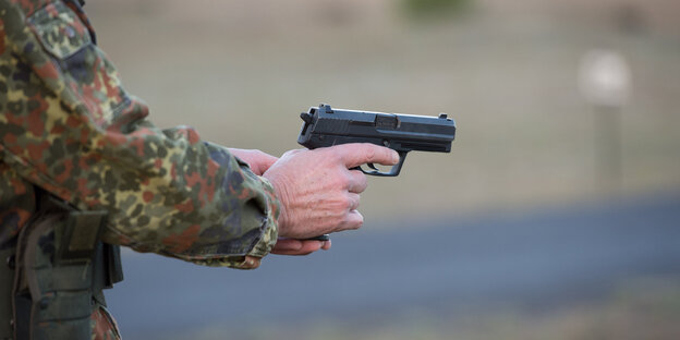 der Arm eines Bundeswehrsoldaten hält eine Schusswaffe der Arm eines Bundeswehrsoldaten hält eine Schusswaffe