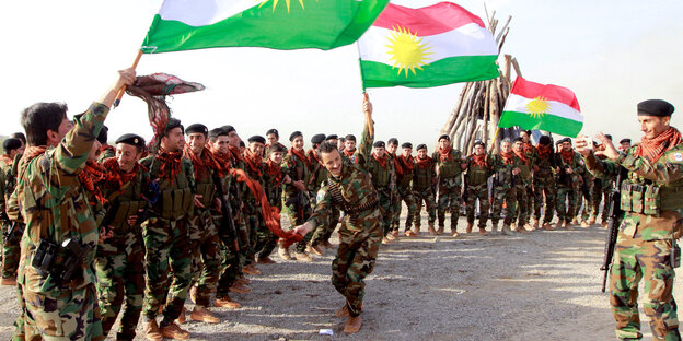 Peshmerga-Kämpfer beim Aufmarsch mit der Flagge Kurdistans Peshmerga-Kämpfer beim Aufmarsch mit der Flagge Kurdistans