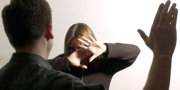Ein Mann erhebt die Hand gegen eine Frau Ein Mann erhebt die Hand gegen eine Frau