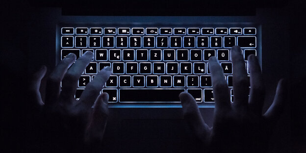 Hände auf einer beleuchteten Tastatur Hände auf einer beleuchteten Tastatur