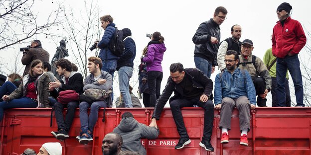 Kind liegt auf einem Platz mit Schriftzug Nuit Debout