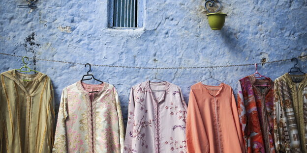 Traditionelle Bekleidung hängt in der Altstadt von Chefchaouen, Marokko, vor einem Geschäft