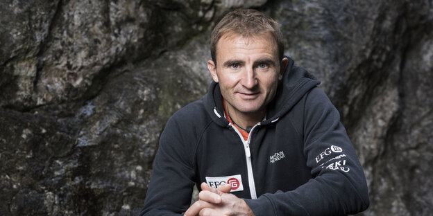 Ein Mann in einer Kapuzenjacke von einer Felswand Ein Mann in einer Kapuzenjacke von einer Felswand
