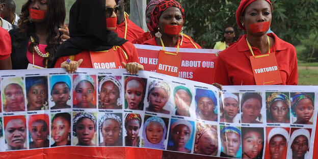 Demonstrierende tragen ein Transparent mit Bildern von den entführten Chibok-Mädchen Demonstrierende tragen ein Transparent mit Bildern von den entführten Chibok-Mädchen