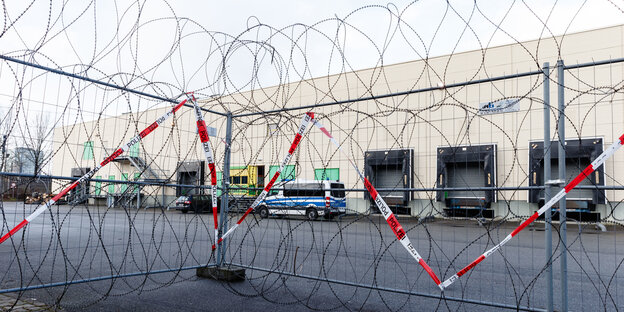 ein Absperrgitter mit Stacheldraht auf dem Parkplatz eines Logistikunternehemens ein Absperrgitter mit Stacheldraht auf dem Parkplatz eines Logistikunternehemens