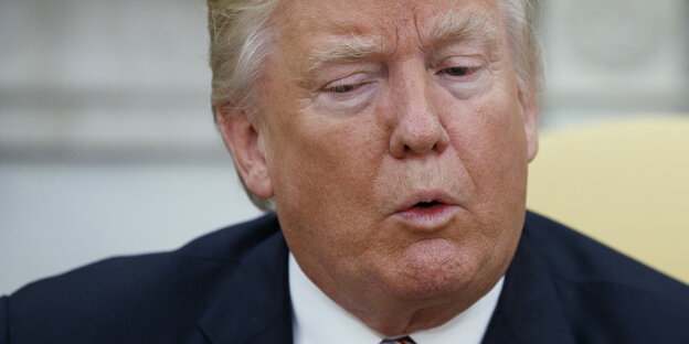 Donald Trump spitzt die Lippen und schaut schräg nach unten Donald Trump spitzt die Lippen und schaut schräg nach unten