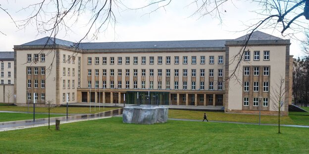 Ein Gebäude mit einer Wiese davor Ein Gebäude mit einer Wiese davor