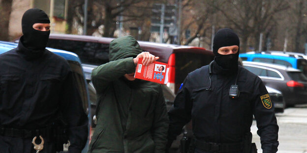 Polizisten führen einen Mann nach einer Razzia gegen die „Freie Kameradschaft Dresden“ zum Amtsgericht Polizisten führen einen Mann nach einer Razzia gegen die „Freie Kameradschaft Dresden“ zum Amtsgericht