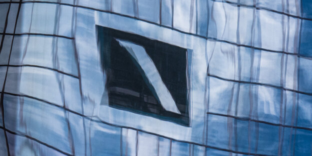 Ein Kasten mit Querstrich, das Emblem der Deutschen Bank, spiegelt sich in Fensterscheiben. Ein Kasten mit Querstrich, das Emblem der Deutschen Bank, spiegelt sich in Fensterscheiben.