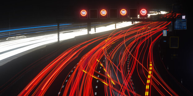 Langzeitbelichtung zeigt rote Leuchtspuren von PKW und LKW auf der Autobahn Langzeitbelichtung zeigt rote Leuchtspuren von PKW und LKW auf der Autobahn