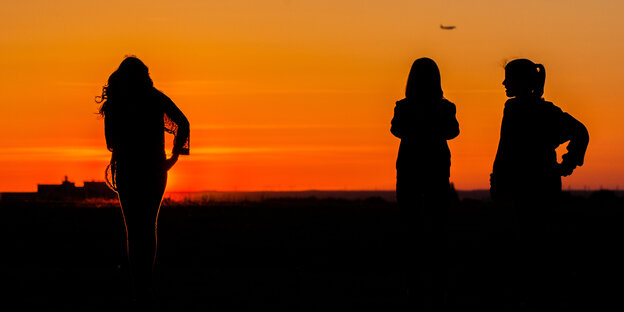 Silhouetten von drei Mädchen im Sonnenuntergang Silhouetten von drei Mädchen im Sonnenuntergang
