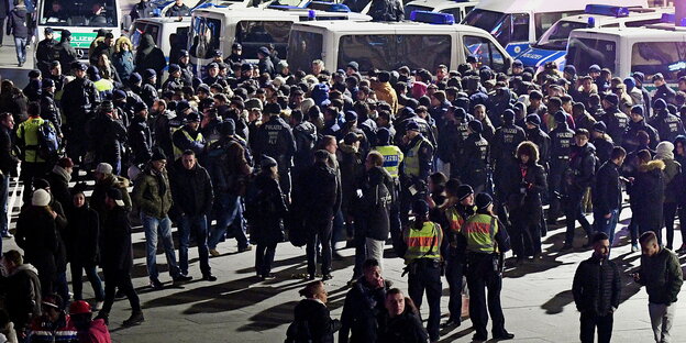 Polizisten umringen eine Menschenmenge Polizisten umringen eine Menschenmenge
