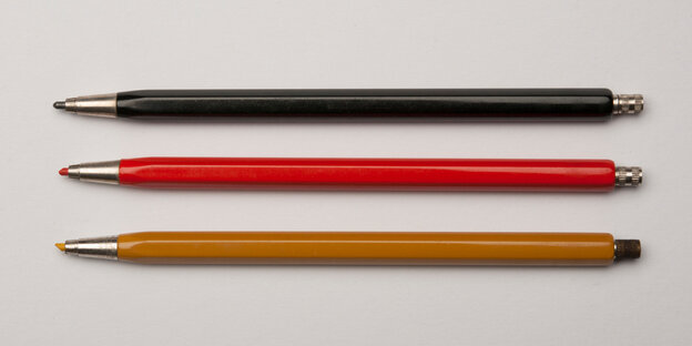 Drei Stifte, fein säuberlich übereinander aufgereit. In schwarz, rot und gold Drei Stifte, fein säuberlich übereinander aufgereit. In schwarz, rot und gold