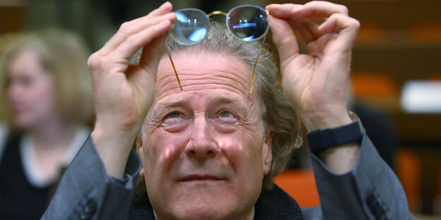 Joachim Bauer hält seine Brille ins Licht Joachim Bauer hält seine Brille ins Licht