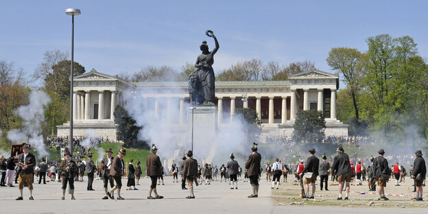 Bayern in Lederhosen stehen versprengt auf der Theresienwiese und schauen hoch zur Statue der Bavaria Bayern in Lederhosen stehen versprengt auf der Theresienwiese und schauen hoch zur Statue der Bavaria