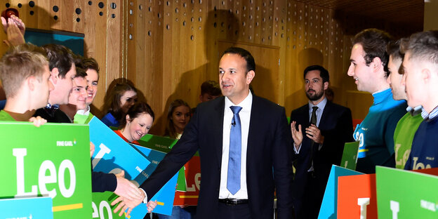 Leo Varadkar umringt von jungen Männern, die Schilder mit der Aufschrift „Leo“ halten Leo Varadkar umringt von jungen Männern, die Schilder mit der Aufschrift „Leo“ halten