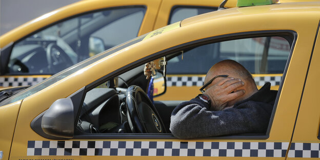 Ein Taxifahrer hält seine Ohren während eines Lärm-Protests gegen Uber Ein Taxifahrer hält seine Ohren während eines Lärm-Protests gegen Uber