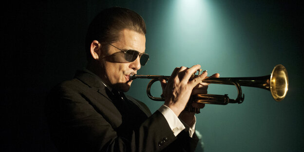 Foto zeigt den Schauspieler Ethan Hawke als Chet Baker, der eine Sonnenbrille trägt und Trompete spielt Foto zeigt den Schauspieler Ethan Hawke als Chet Baker, der eine Sonnenbrille trägt und Trompete spielt
