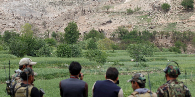 Afghanische Sondereinsatzkräfte begutachten aus der Ferne den Einschlagsort der Bombe Afghanische Sondereinsatzkräfte begutachten aus der Ferne den Einschlagsort der Bombe