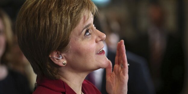 Nicola Sturgeon guckt nach oben und ist dabei, sich die Hand vor den Mund zu schlagen