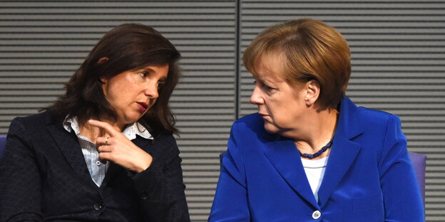 zwei Frauen sitzen nebeneinander und gucken sich an zwei Frauen sitzen nebeneinander und gucken sich an
